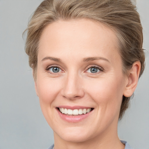 Joyful white adult female with medium  brown hair and grey eyes