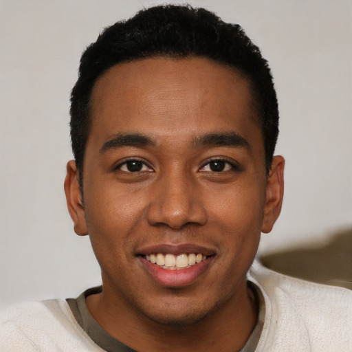 Joyful black young-adult male with short  black hair and brown eyes