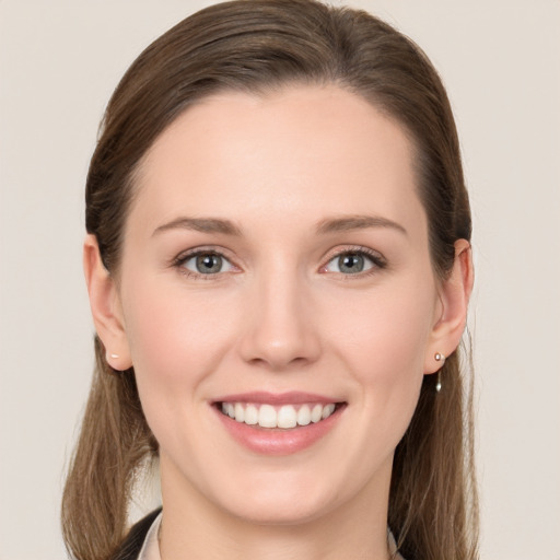 Joyful white young-adult female with long  brown hair and grey eyes