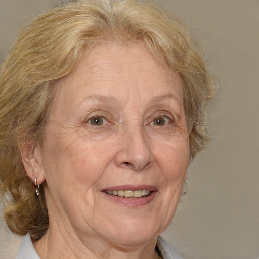 Joyful white middle-aged female with medium  blond hair and grey eyes