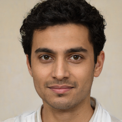 Joyful latino young-adult male with short  black hair and brown eyes