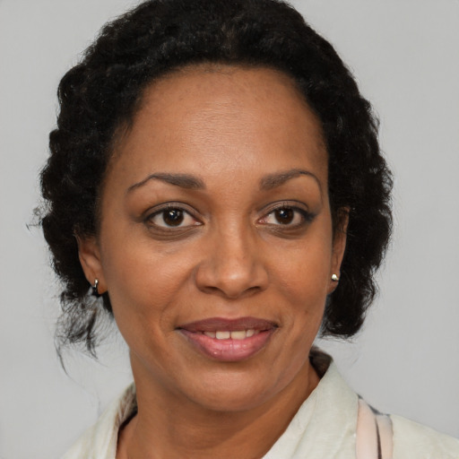 Joyful black adult female with medium  brown hair and brown eyes
