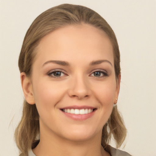 Joyful white young-adult female with long  brown hair and grey eyes