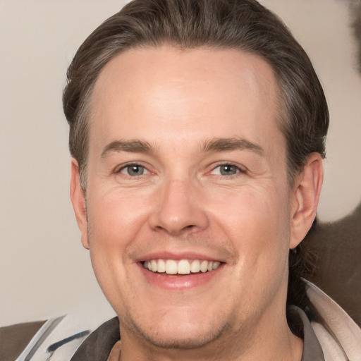 Joyful white adult male with short  brown hair and brown eyes