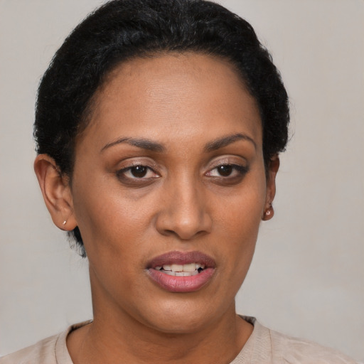 Joyful black young-adult female with short  brown hair and brown eyes