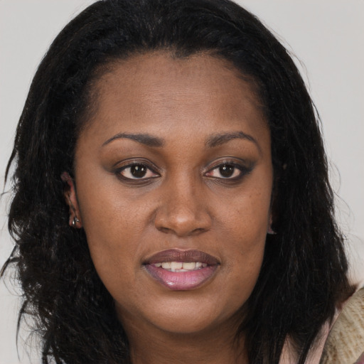 Joyful black young-adult female with long  brown hair and brown eyes