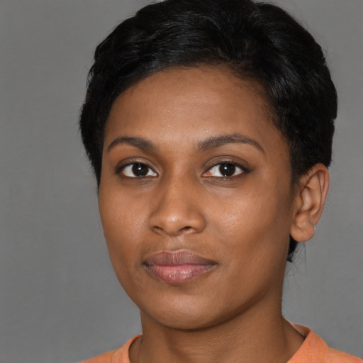 Joyful black young-adult female with short  black hair and brown eyes
