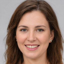 Joyful white young-adult female with long  brown hair and green eyes