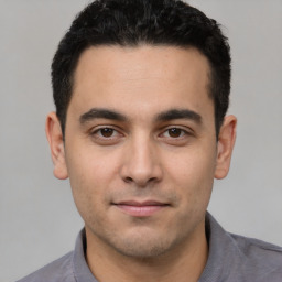 Joyful white young-adult male with short  black hair and brown eyes