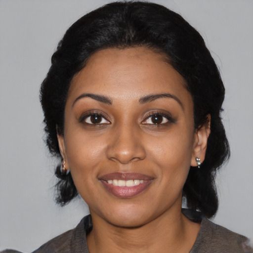 Joyful black young-adult female with medium  black hair and brown eyes