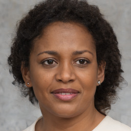 Joyful black adult female with medium  brown hair and brown eyes