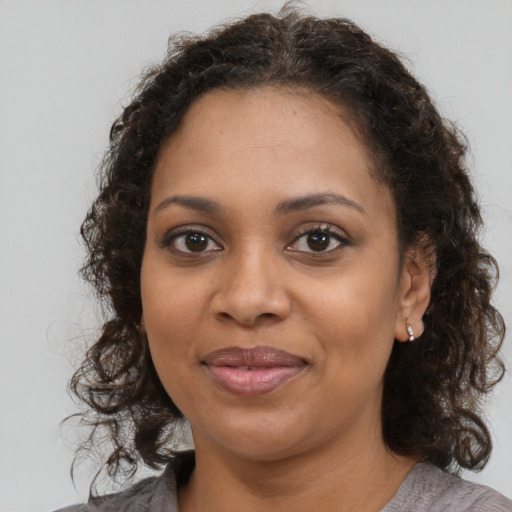Joyful black young-adult female with medium  brown hair and brown eyes