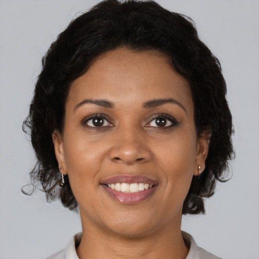 Joyful black young-adult female with medium  brown hair and brown eyes