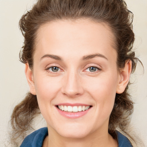 Joyful white young-adult female with medium  brown hair and blue eyes