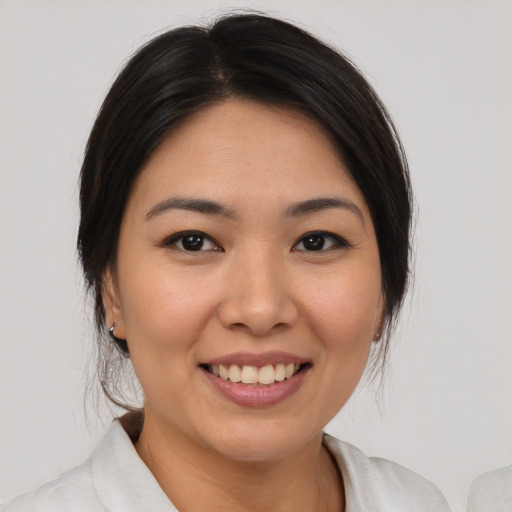 Joyful asian young-adult female with medium  brown hair and brown eyes