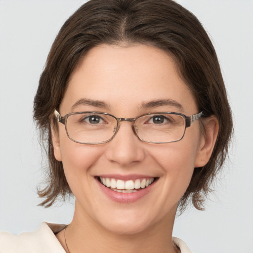 Joyful white young-adult female with medium  brown hair and grey eyes