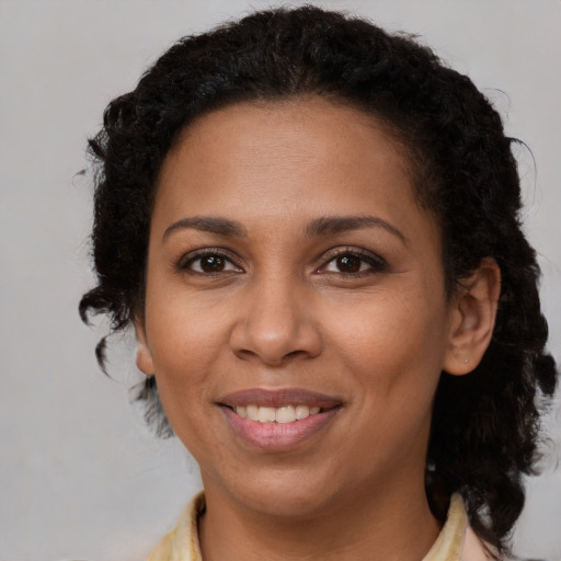 Joyful black adult female with long  brown hair and brown eyes