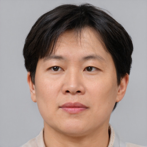 Joyful asian adult male with short  brown hair and brown eyes