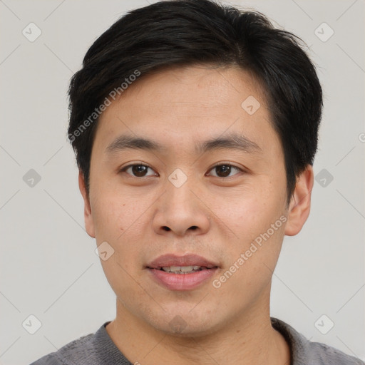 Joyful asian young-adult male with short  brown hair and brown eyes