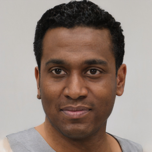 Joyful black young-adult male with short  black hair and brown eyes