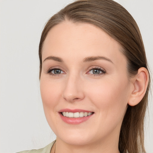 Joyful white young-adult female with long  brown hair and blue eyes