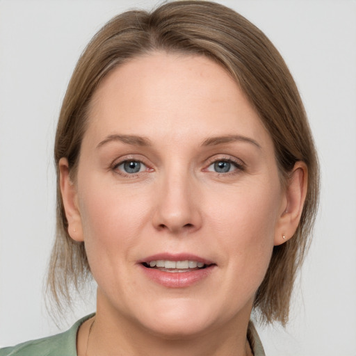 Joyful white adult female with medium  brown hair and grey eyes