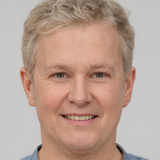 Joyful white middle-aged male with short  brown hair and grey eyes