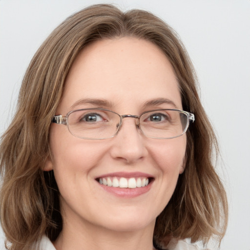 Joyful white adult female with long  brown hair and blue eyes