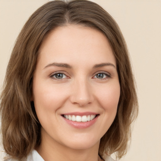 Joyful white young-adult female with medium  brown hair and green eyes