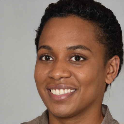 Joyful black young-adult female with short  brown hair and brown eyes