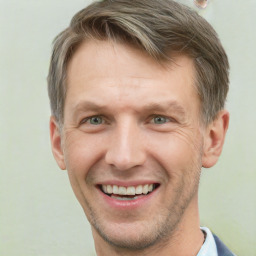 Joyful white adult male with short  brown hair and grey eyes