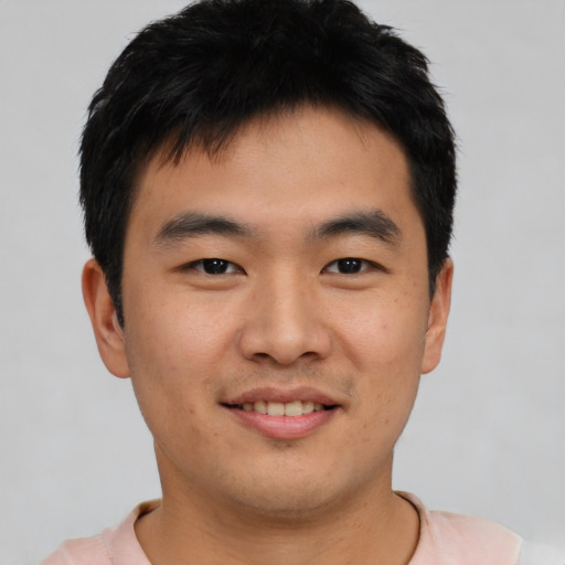 Joyful asian young-adult male with short  brown hair and brown eyes