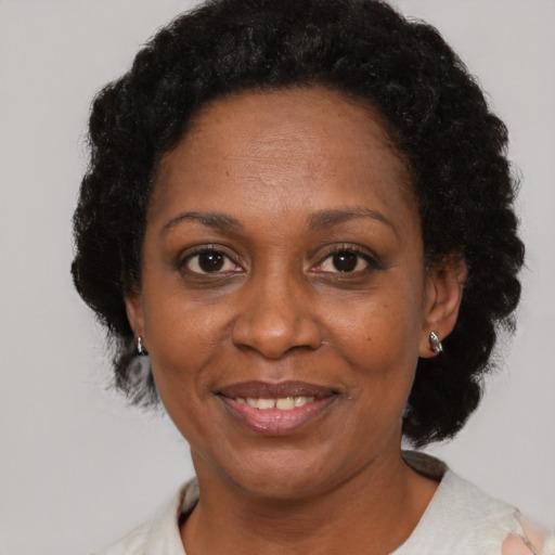 Joyful black adult female with short  brown hair and brown eyes