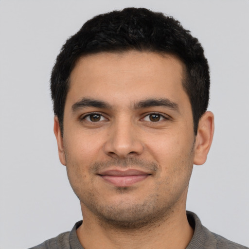 Joyful latino young-adult male with short  black hair and brown eyes