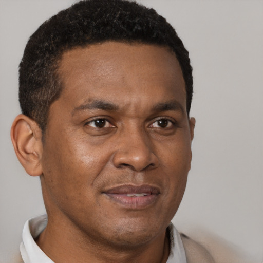 Joyful black young-adult male with short  brown hair and brown eyes