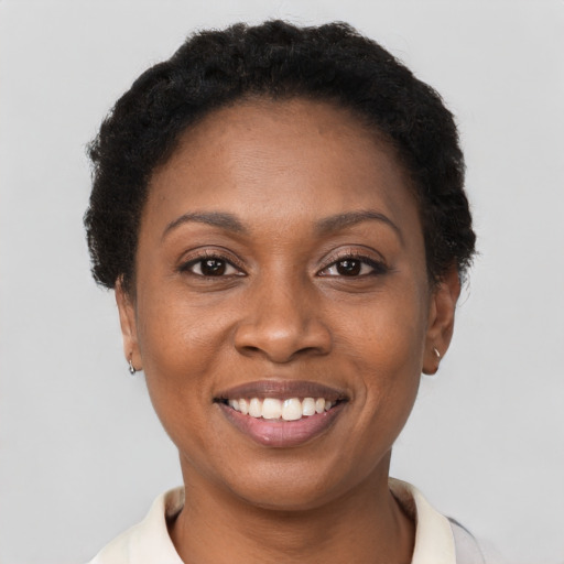 Joyful black young-adult female with short  brown hair and brown eyes