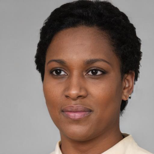 Joyful black young-adult female with short  black hair and brown eyes