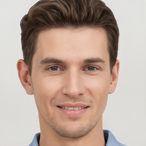 Joyful white young-adult male with short  brown hair and grey eyes