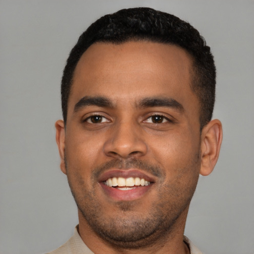 Joyful black young-adult male with short  black hair and brown eyes