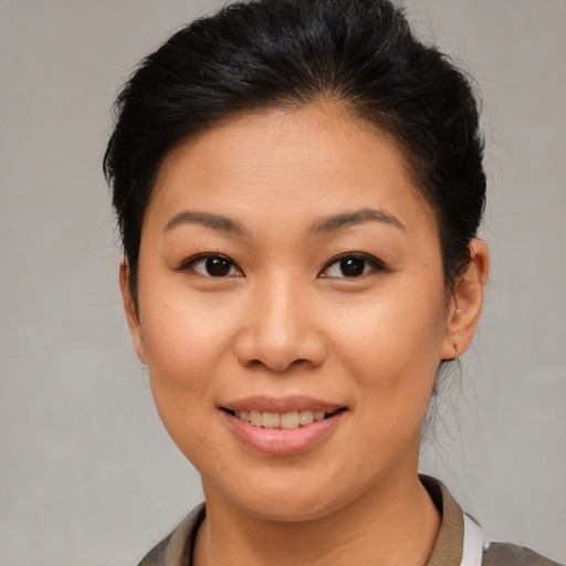 Joyful asian young-adult female with short  brown hair and brown eyes