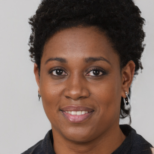 Joyful black young-adult female with short  brown hair and brown eyes