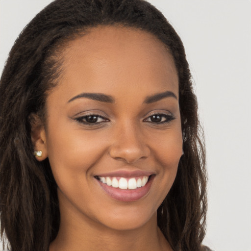 Joyful latino young-adult female with long  brown hair and brown eyes