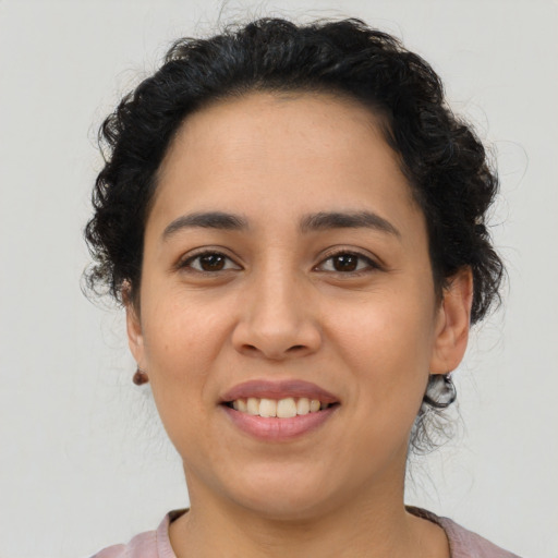 Joyful latino young-adult female with medium  brown hair and brown eyes