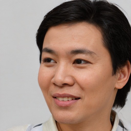 Joyful asian young-adult male with medium  brown hair and brown eyes