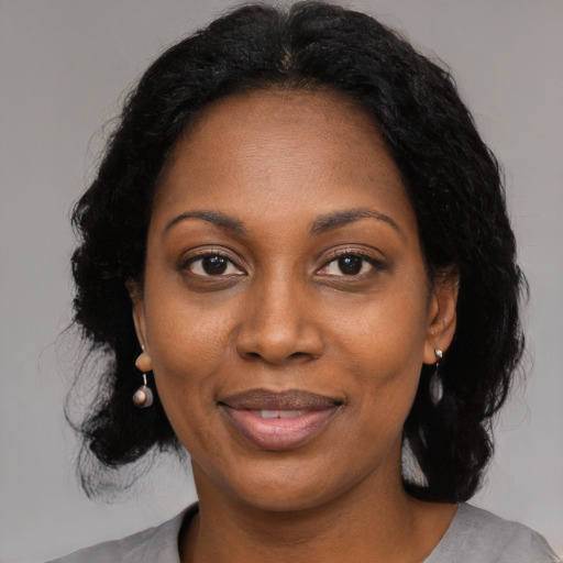 Joyful black adult female with long  black hair and brown eyes