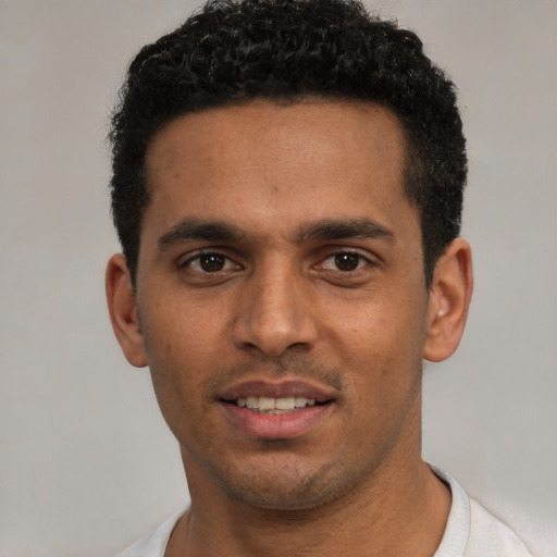 Joyful white young-adult male with short  black hair and brown eyes