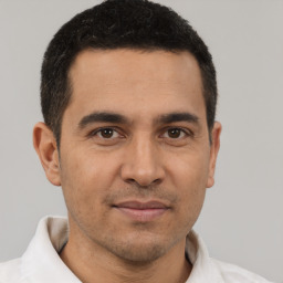 Joyful latino young-adult male with short  brown hair and brown eyes
