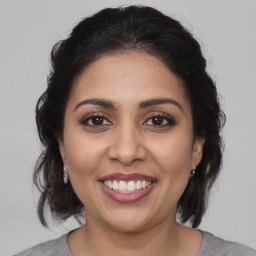 Joyful latino young-adult female with medium  brown hair and brown eyes