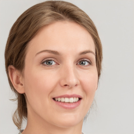 Joyful white young-adult female with medium  brown hair and grey eyes