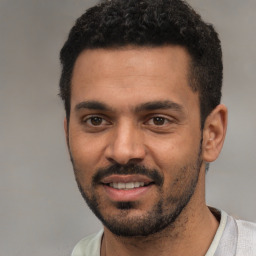 Joyful white young-adult male with short  black hair and brown eyes